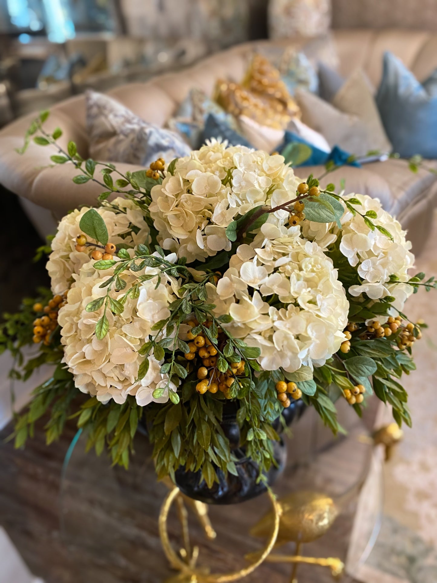 Hydrangeas draping greenery berries distress roman vase arrangement